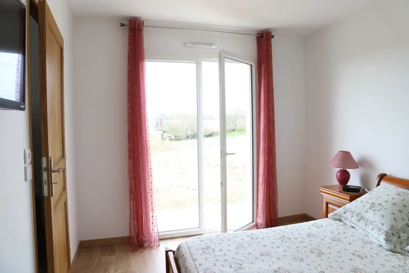 Porte-fenêtre PVC FPEE Concerto blanche à deux vantaux dans une chambre