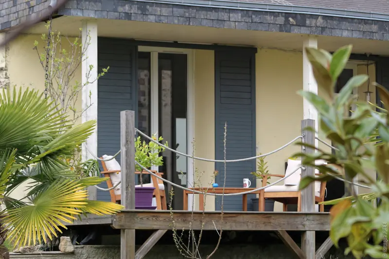 Portes-fenêtres RFP® FPEE Novelia gris anthracite et volets aluminium sur une maison à véranda